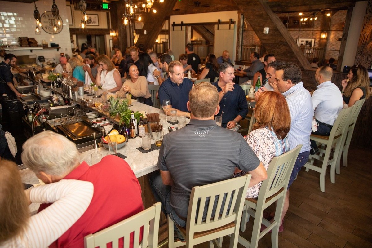 Season ticket holders dining at a coastal Naples restaurant in the evening